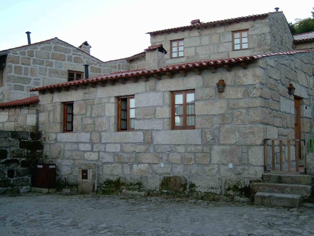 un antico edificio in pietra con finestre e cancello di One Bedroom House in Povoa Dao a Povoa Dao