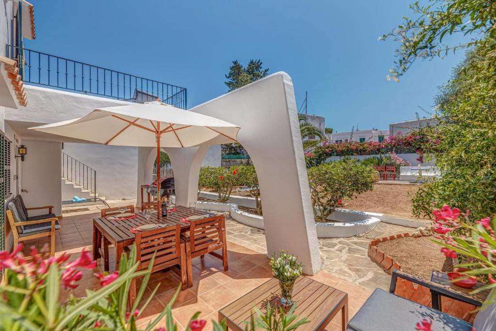 a patio with a table and an umbrella at Sweet Family House in Cala d´Or