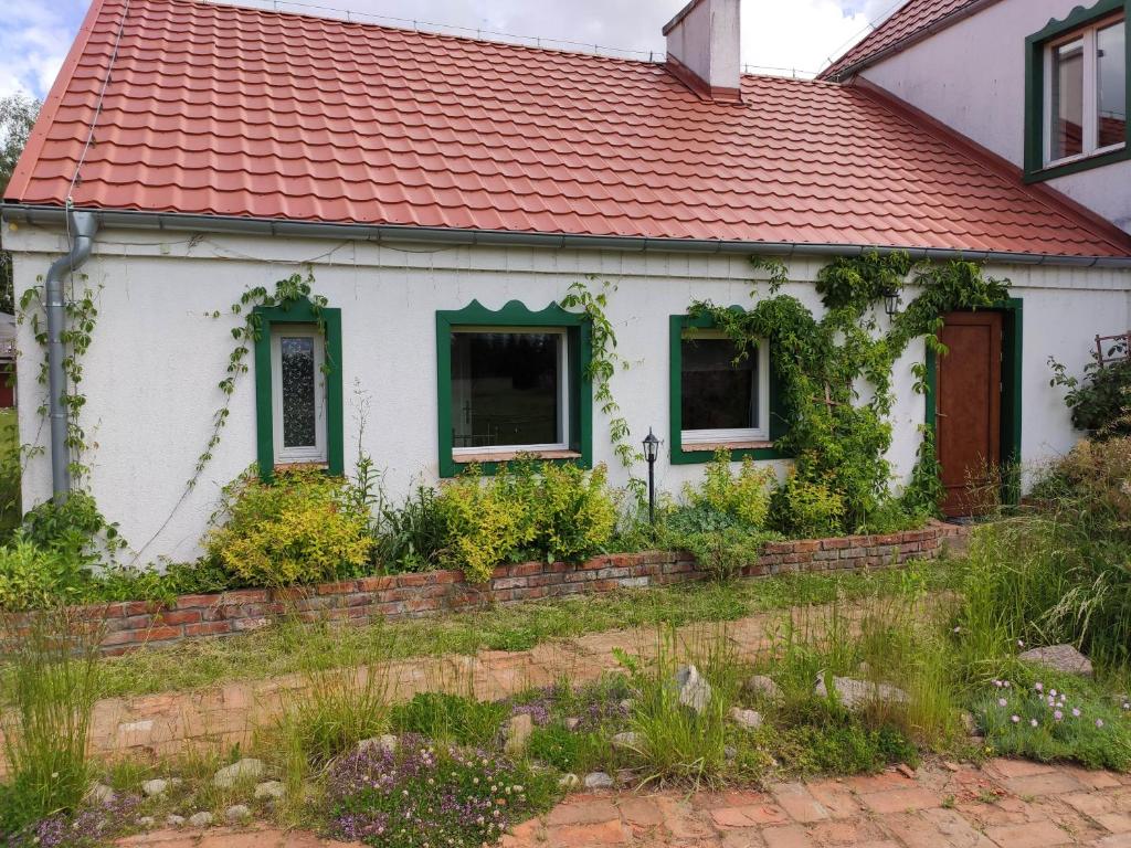 une maison blanche avec un toit rouge dans l'établissement Srokowski Dwór 1 - Dom Ochmistrza, à Srokowo