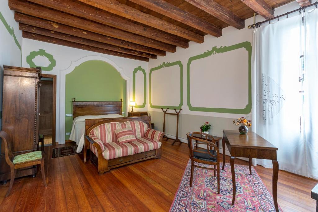 um quarto com uma cama, uma secretária e uma cadeira em Palazzo Scolari em Polcenigo