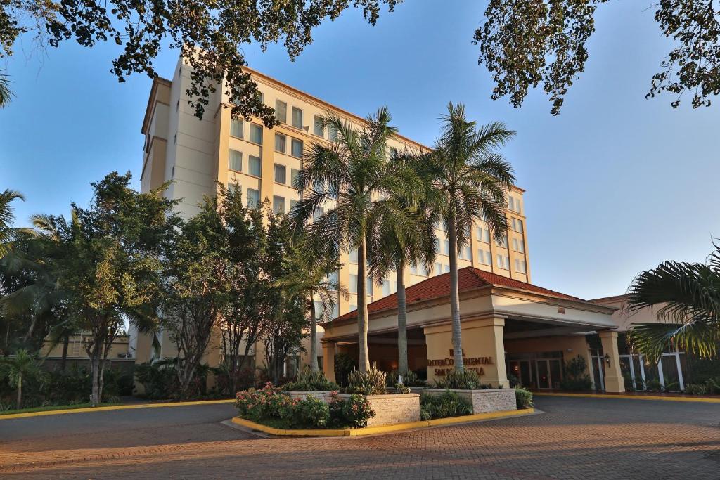 a building with palm trees in front of it at Hotel Real InterContinental San Pedro Sula, an IHG Hotel in San Pedro Sula