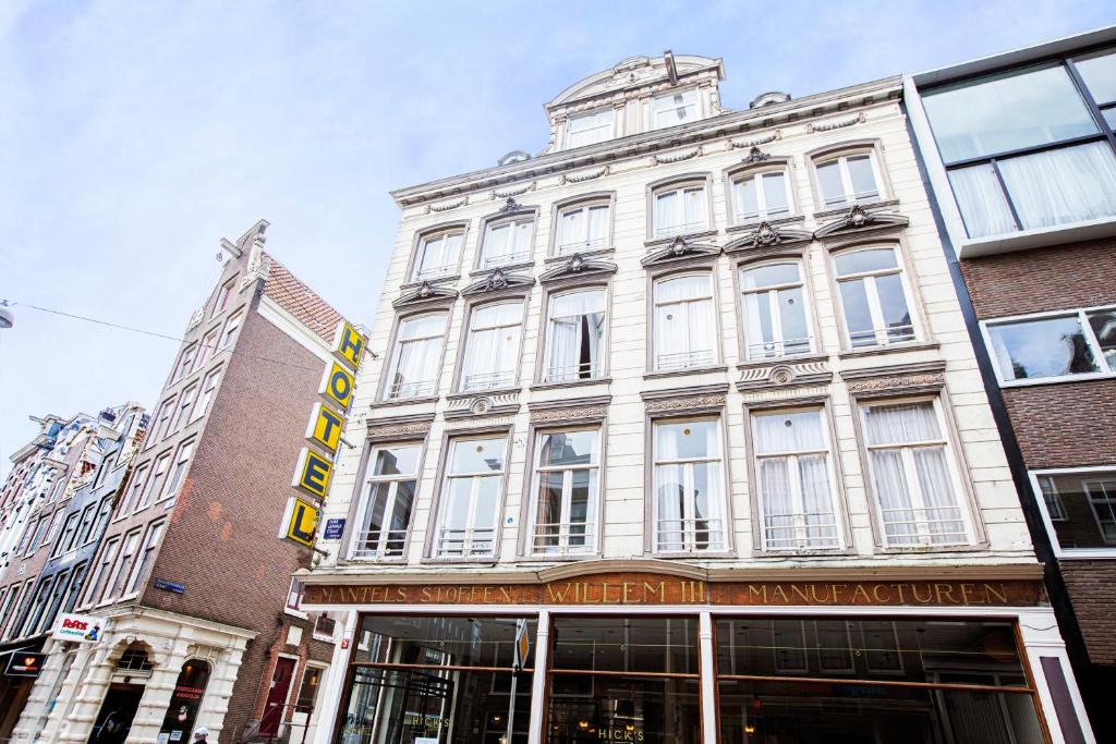 a large white building on a city street at Quentin Arrive Hotel in Amsterdam