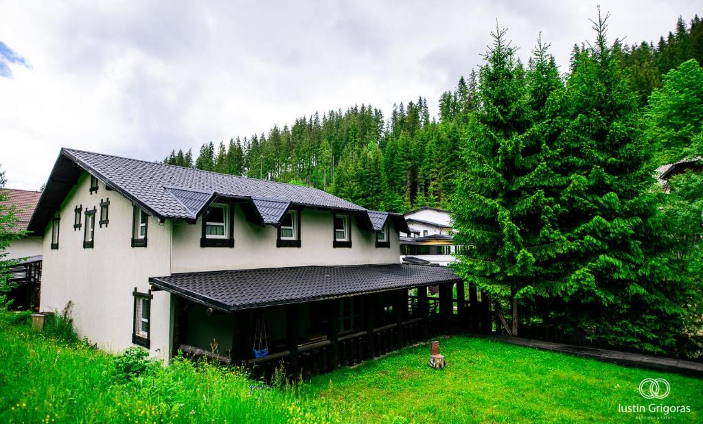 a large white house with a black roof at Coliba Drumetului in Vatra Dornei