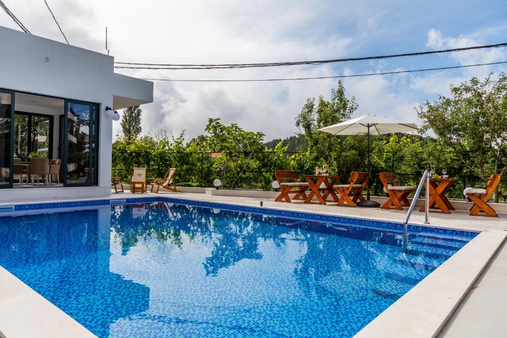 布德瓦的住宿－Alt Braic Villa，一个带椅子和遮阳伞的游泳池