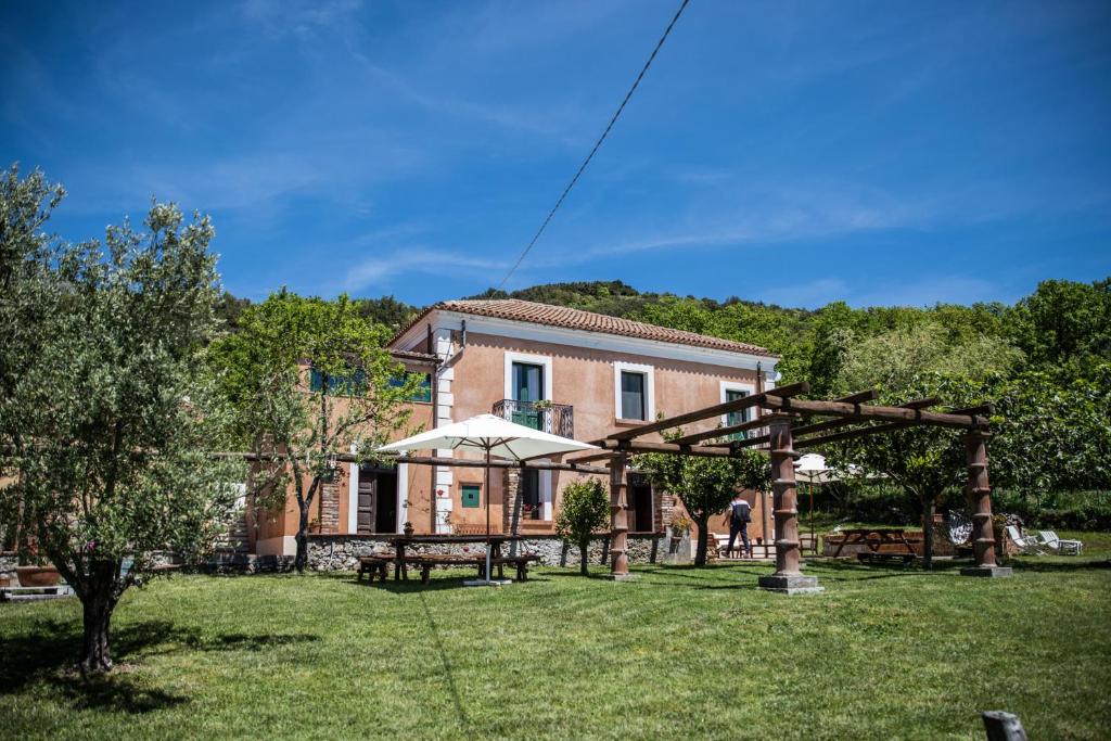 a house with an outdoor patio and an arbor at Casale De Filippo in Maratea