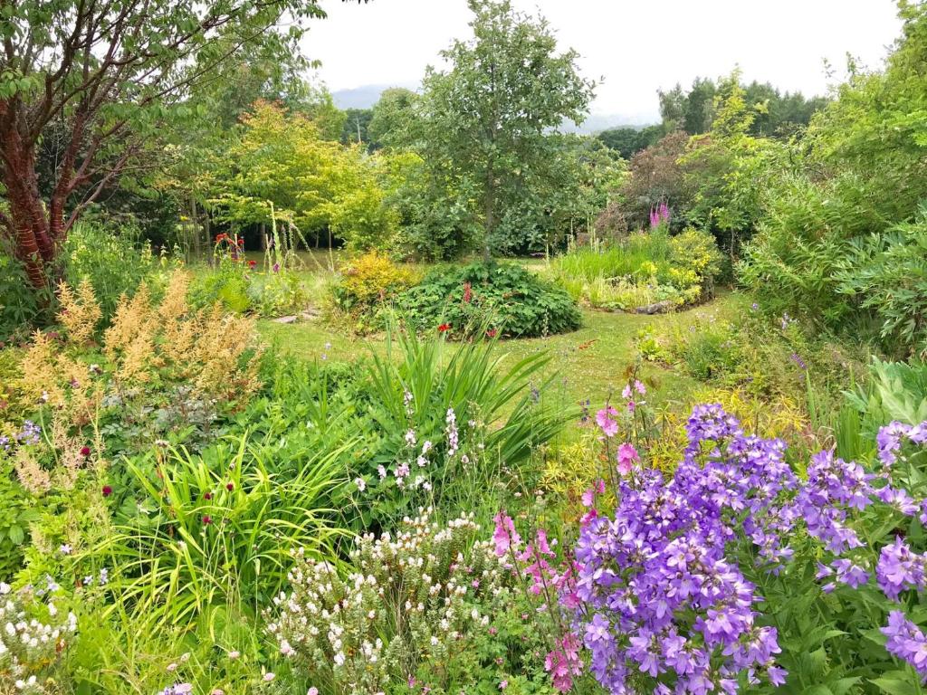 un jardín con flores y plantas coloridas en Blairchroisk Cottage en Pitlochry