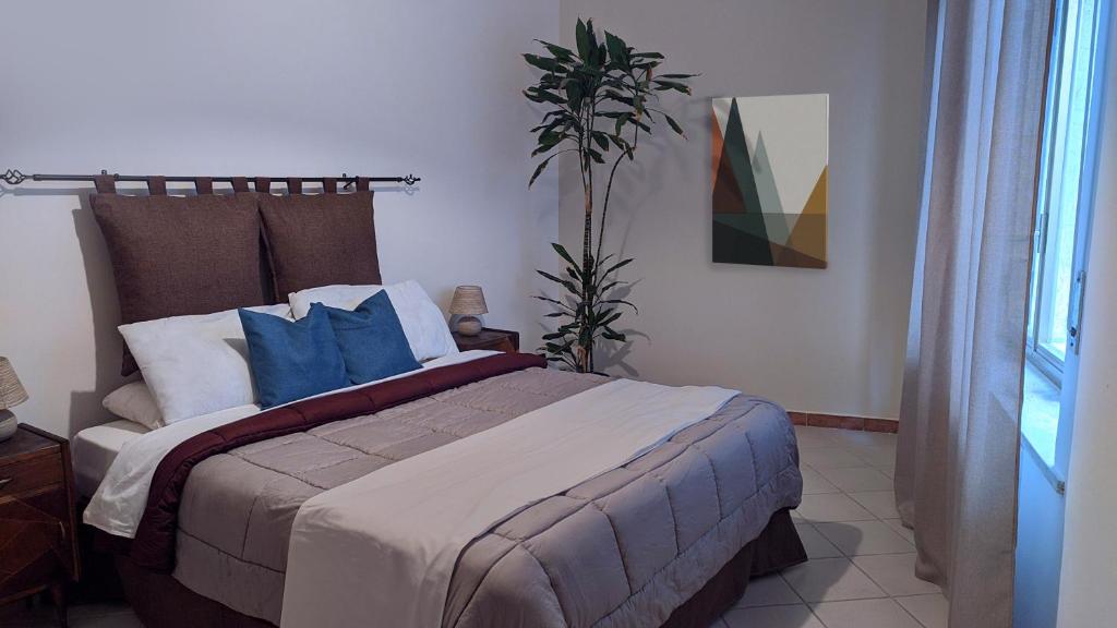a bedroom with a large bed with blue pillows at TOP Apartment in Catanzaro
