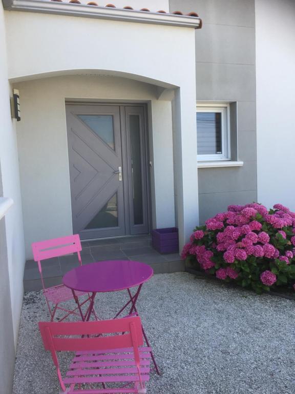 una mesa rosa y una silla rosa frente a una casa en Chambre les Hortensias, en Challans