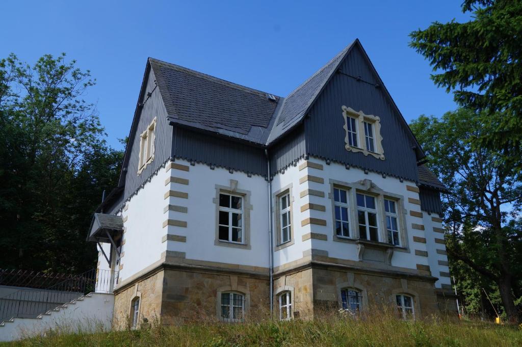 ein altes Haus mit schwarzem Dach in der Unterkunft Villa Unger in Kurort Altenberg