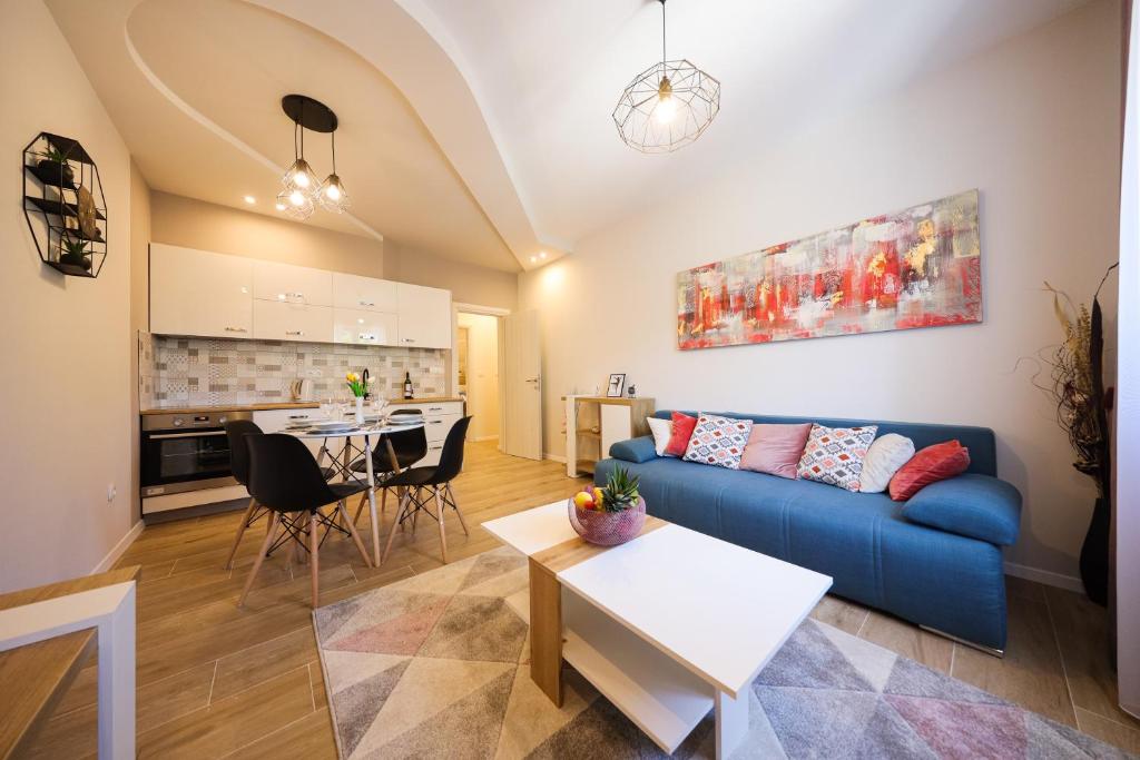 ein Wohnzimmer mit einem blauen Sofa und einem Tisch in der Unterkunft Apartment Ventum in Zadar