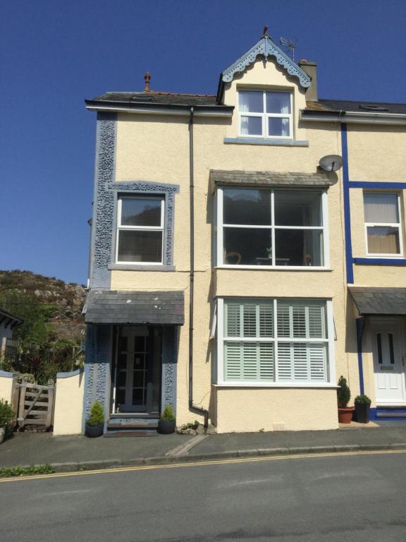 a white house with a window and a door at Ty'n y Gwynt in Criccieth