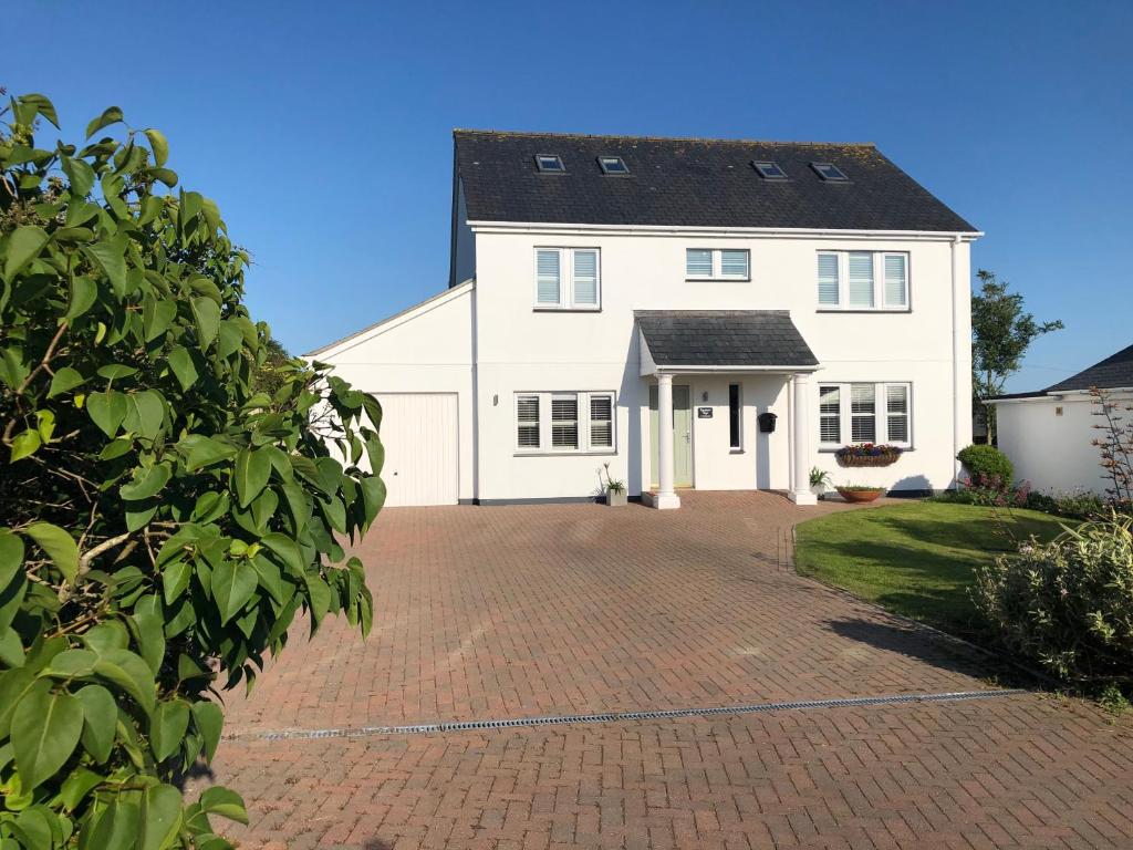 Una gran casa blanca con una entrada de ladrillo en Rosenn Teyr, en St. Agnes