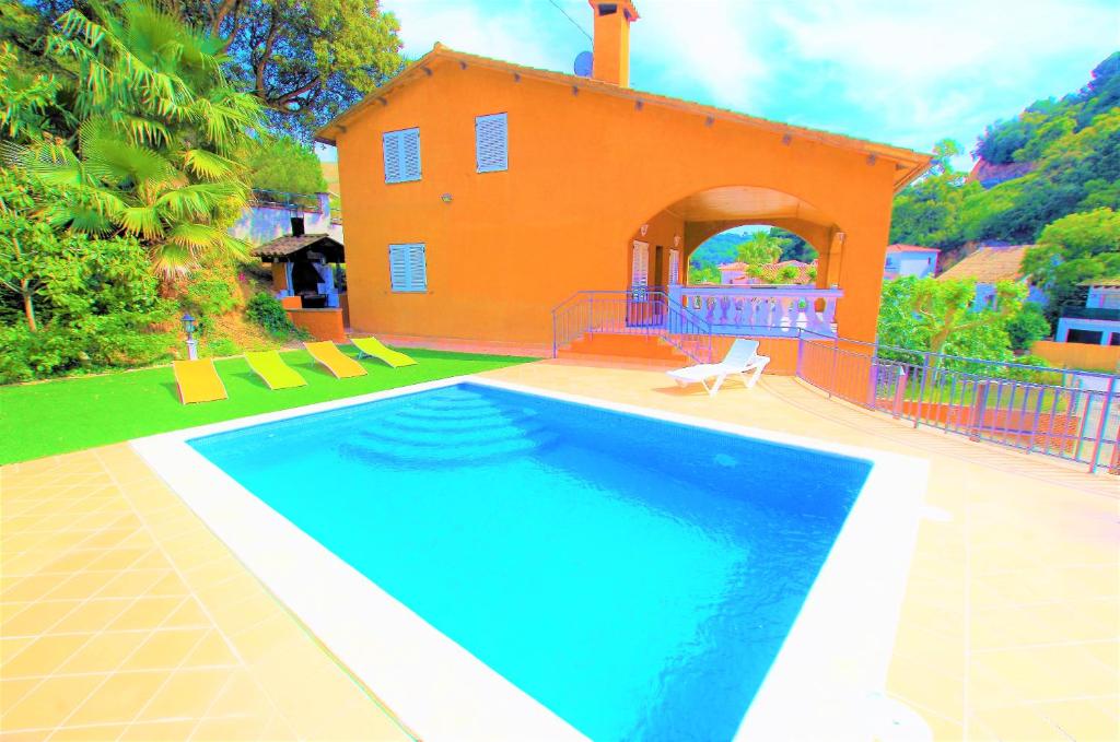 una casa con piscina frente a una casa en V&V LLORET - VILLA CANYELLES preciosa villa para 8PAX con piscina privada y barbacoa a solo 800m de playa Cala Canyelles, en Lloret de Mar