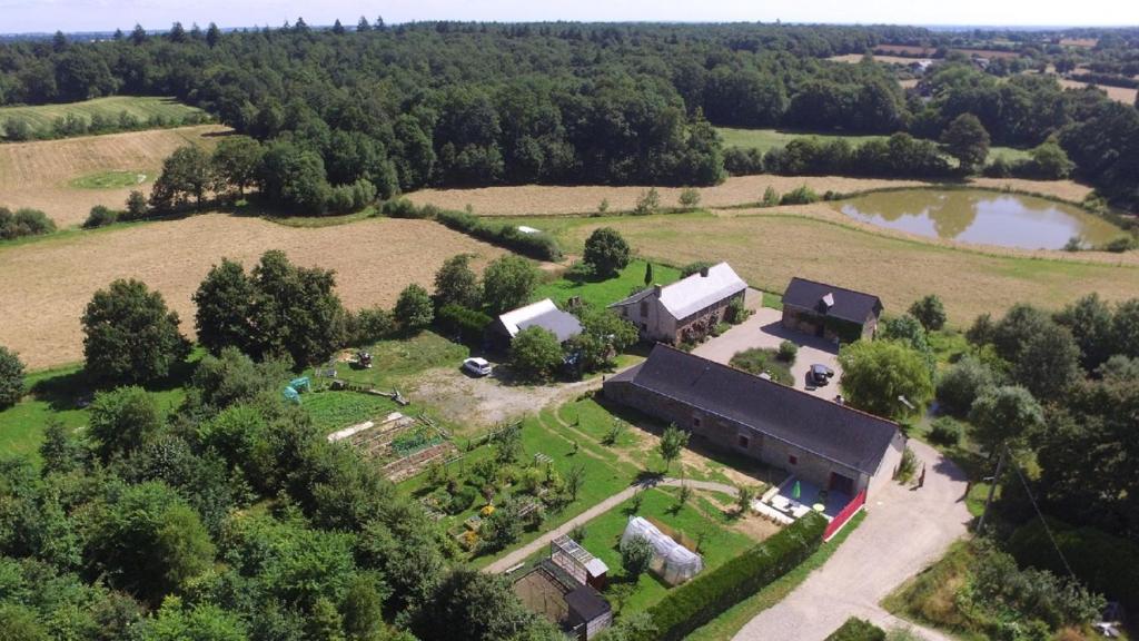uma vista aérea de uma quinta com um edifício e um lago em Mon Savoureux Jardin em Challain-la-Potherie