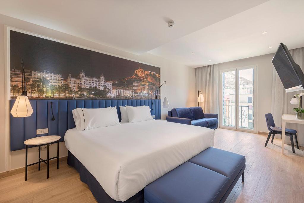 um quarto com uma cama grande e uma parede azul em Eurostars Mediterranea Plaza em Alicante