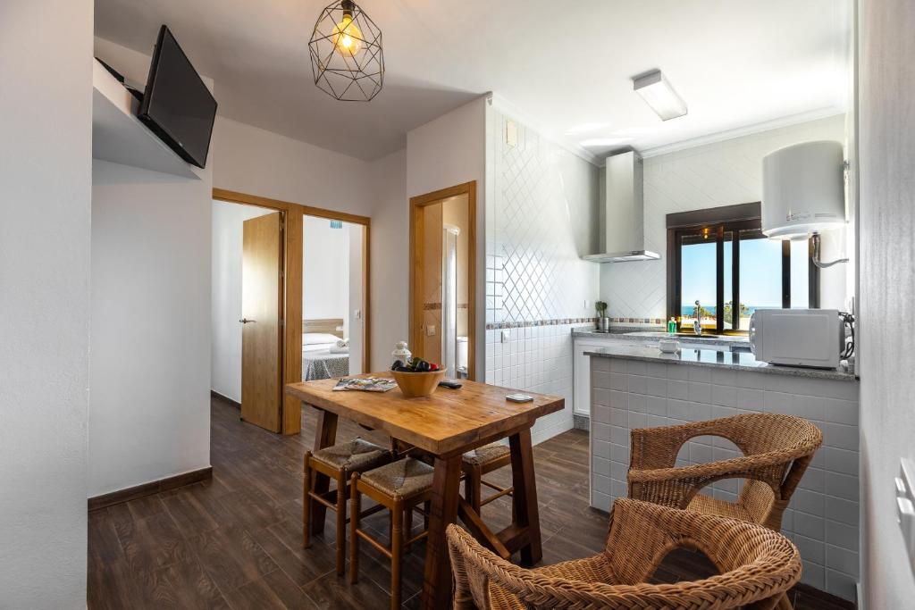 a kitchen and dining room with a wooden table and chairs at APARTAMENTO BOLONIA SUR B in Tarifa