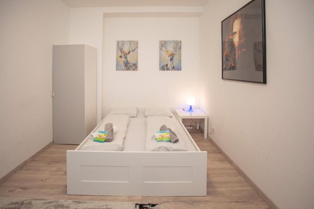 Cama blanca en habitación blanca con mesa en City Center Apartment, en Innsbruck