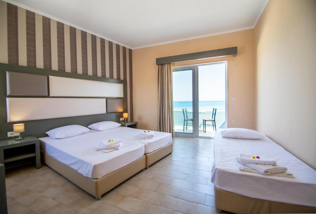 a bedroom with two beds with a view of the ocean at Aktypis Beachfront Studios in Laganas
