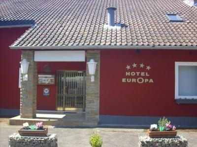 un edificio rojo con una puerta y algunas plantas en Hotel Europa, en Holsthum