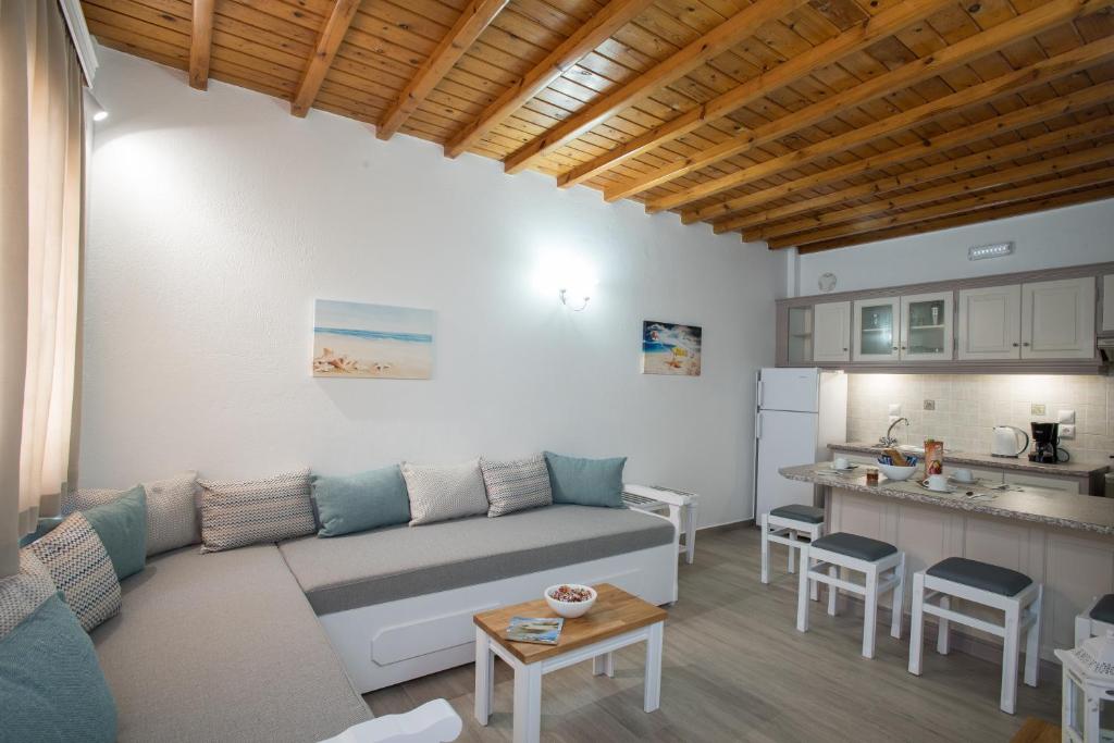 a living room with a couch and a kitchen at Filoxenia Apartments in Ornos