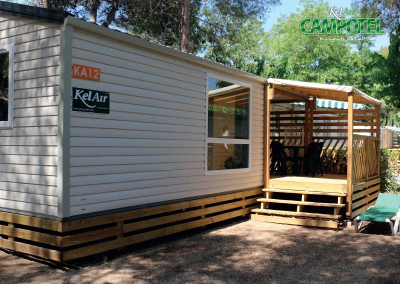 a tiny house with a porch and a deck at Mobile Homes by KelAir at Castell Montgri in Torroella de Montgrí