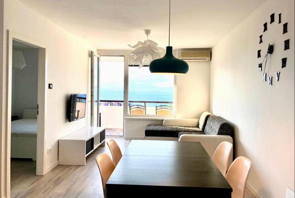 ein Wohnzimmer mit einem Tisch und Meerblick in der Unterkunft Seaview Apartment in Koper