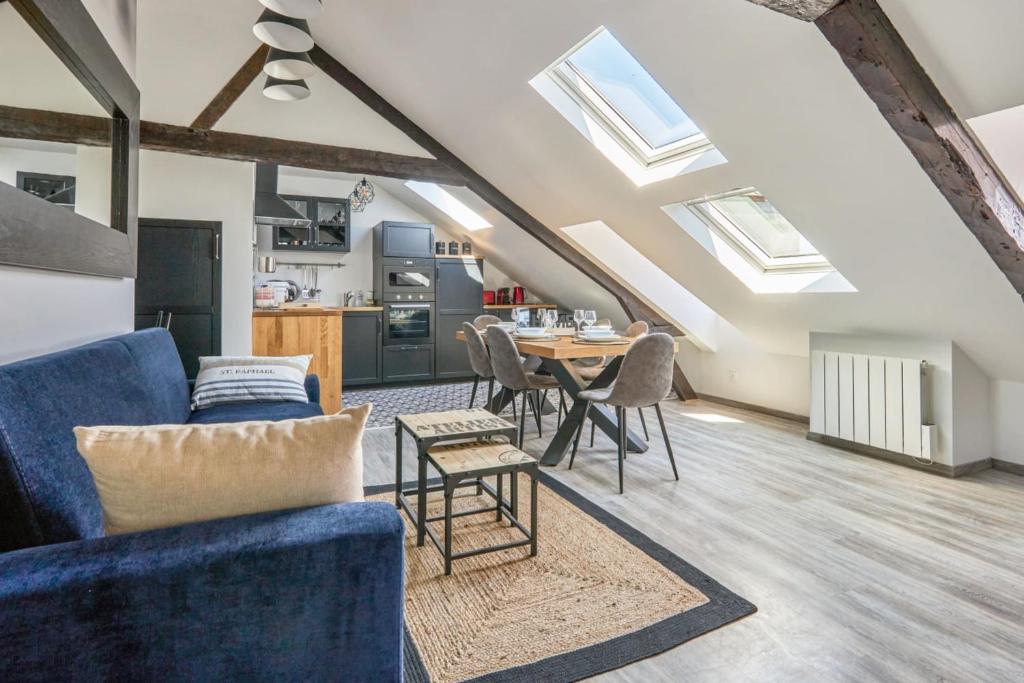 un salon avec un canapé bleu et une table dans l'établissement Appartement Lucarnes - 3 étoiles - Welkeys, à Honfleur
