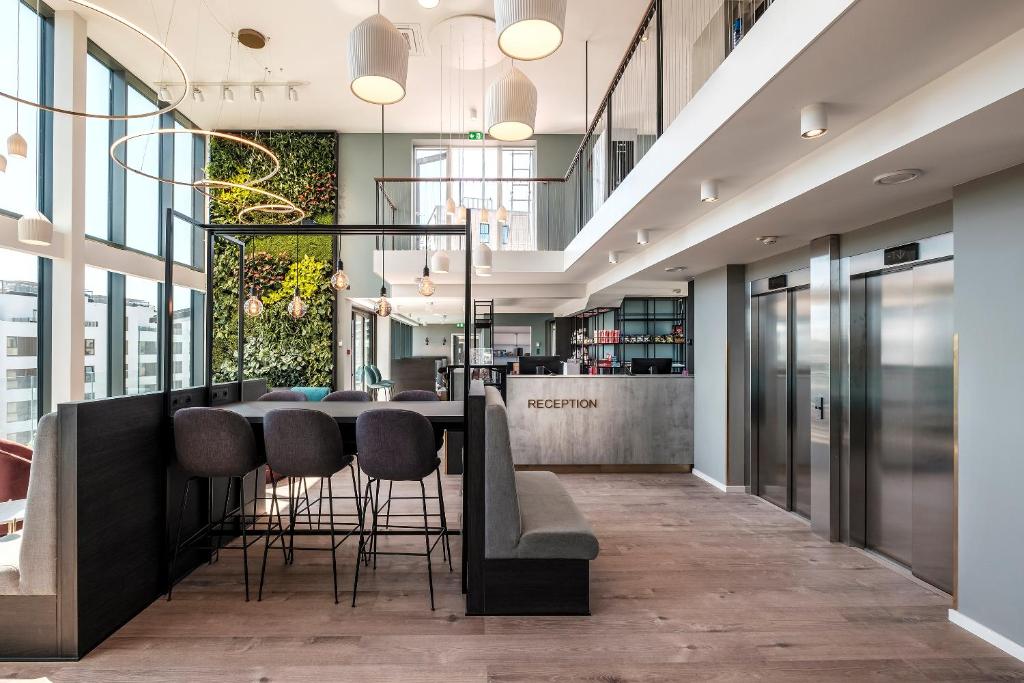 um átrio de escritório com um bar com bancos em Go Hotel City em Copenhaga