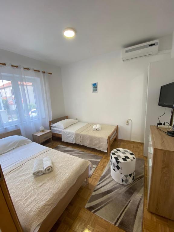pokój hotelowy z dwoma łóżkami i telewizorem w obiekcie Apartman Iva w mieście Zadar