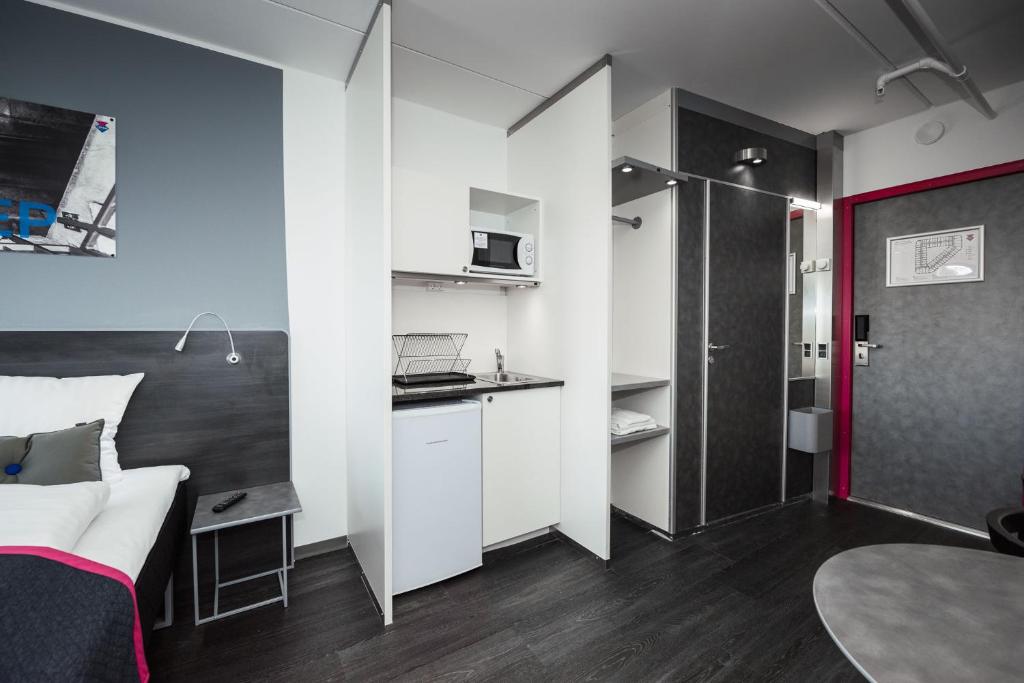 a small room with a bed and a small kitchen at Cabinn Copenhagen in Copenhagen