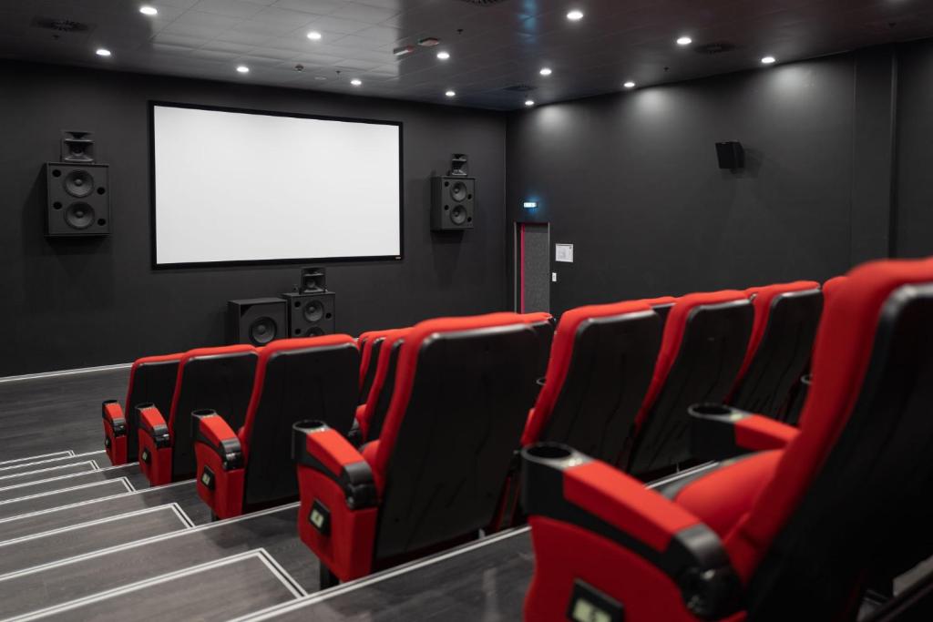 a cinema room with red chairs and a blank screen at Cabinn Copenhagen in Copenhagen