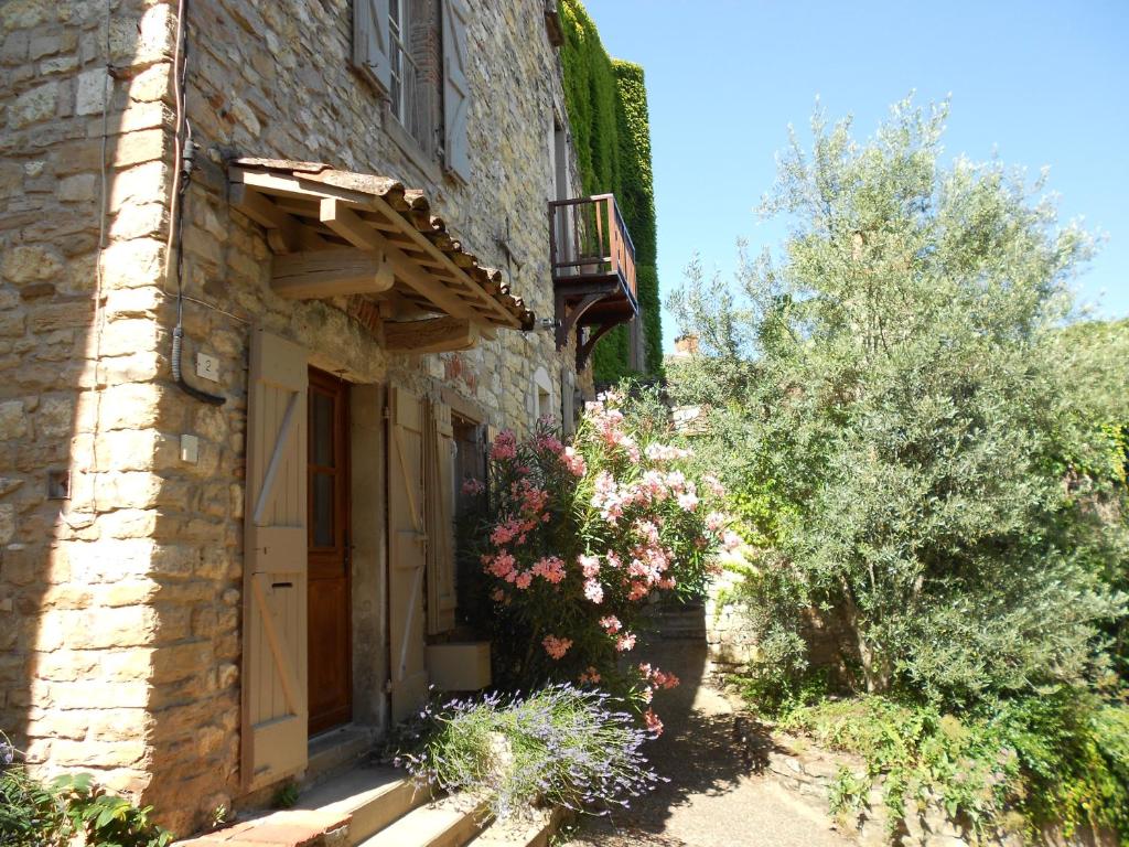 un edificio in pietra con dei fiori sul lato di Rue du Barri a Cordes-sur-Ciel