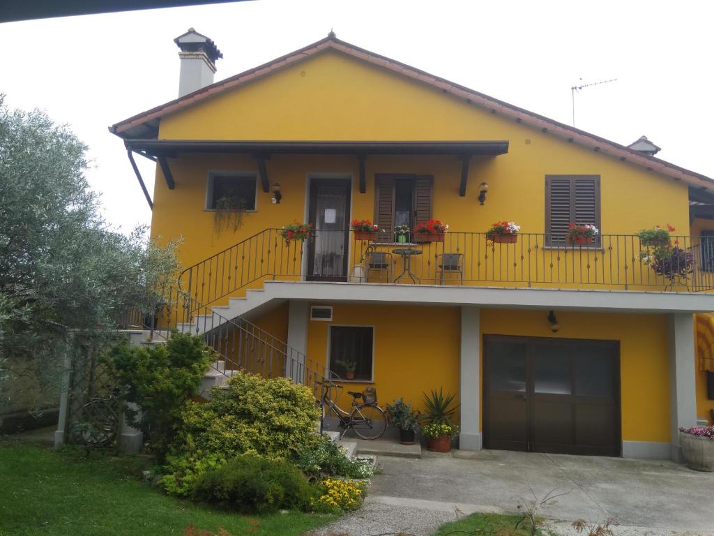 Casa amarilla con balcón en B&B NONO TILIO, en Talmassons
