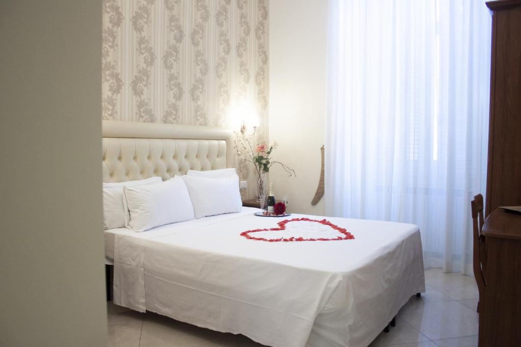 een slaapkamer met een wit bed met een rode jurk erop bij Suite Dal Conte in Rome