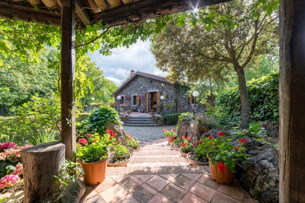 a garden with flowers and a stone house at Villa Il Castagno dell'Etna in Maletto