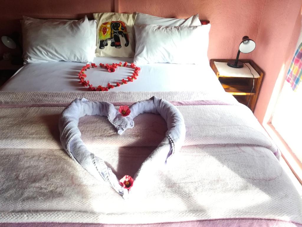 Una cama con un corazón hecho de flores rojas en Sincere Wilderness Home stay, en Nuwara Eliya