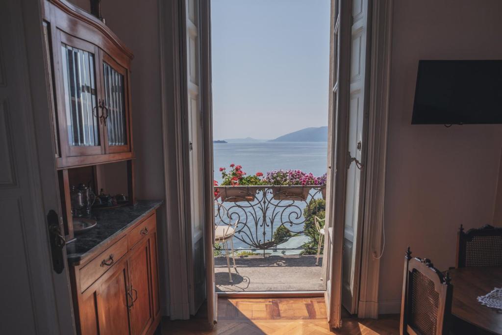 una puerta abierta a un balcón con vistas al océano en Villa Selva Luxury Lakeview Apartment, en Ghiffa