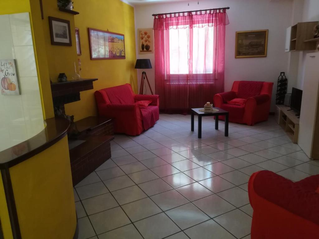 uma sala de estar com duas cadeiras vermelhas e uma mesa em ANGOLO FELICE B&B em Castignano