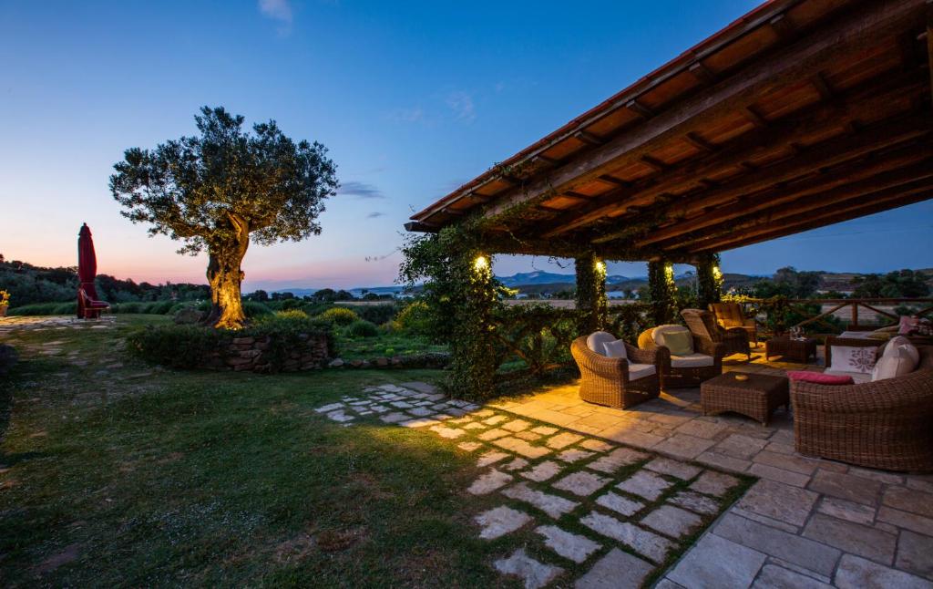 Cette maison dispose d'une terrasse avec des chaises et un arbre. dans l'établissement Torre di Baratti Bio Resort, à Populonia