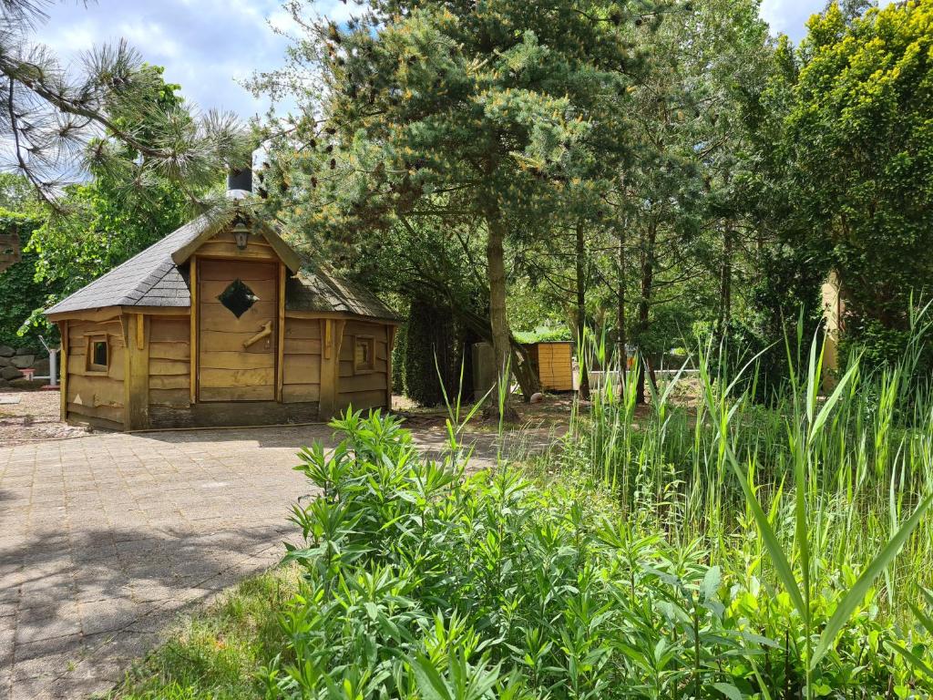 een kleine houten hut in een tuin met bomen bij Ferienwohnungen Margaretenhof, Plaue in Margarethenhof