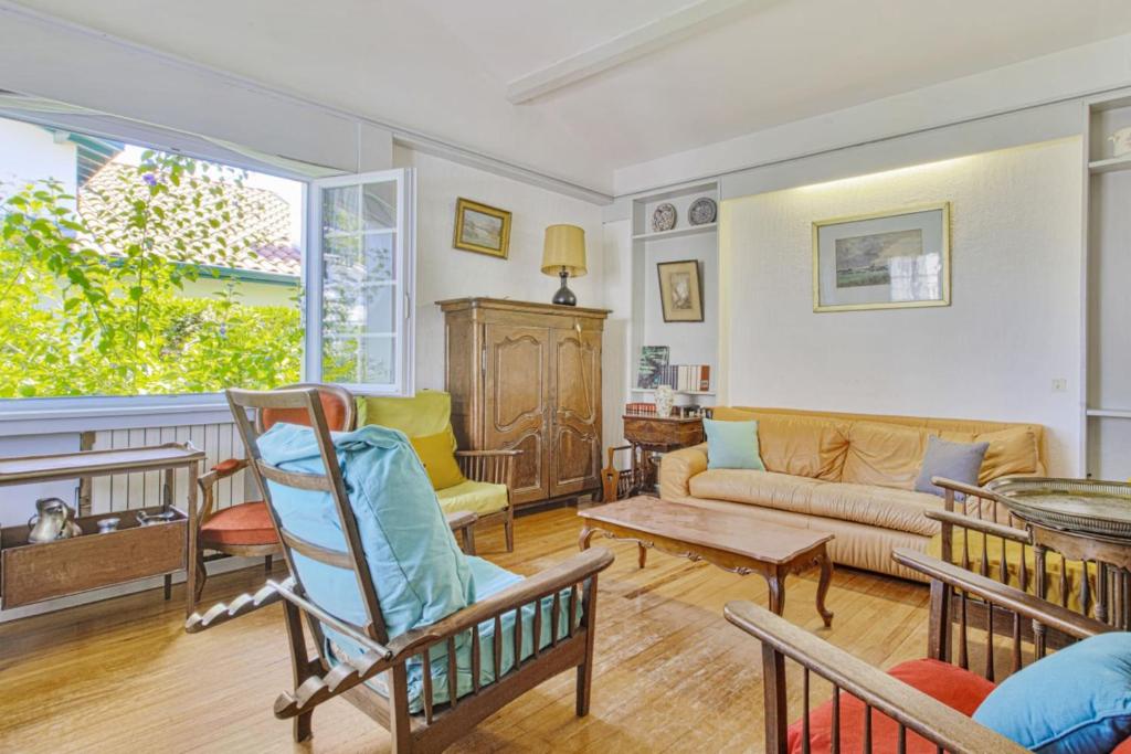 ein Wohnzimmer mit einem Sofa und einem Tisch in der Unterkunft Charming Basque villa with garden - Bayonne - Welkeys in Bayonne