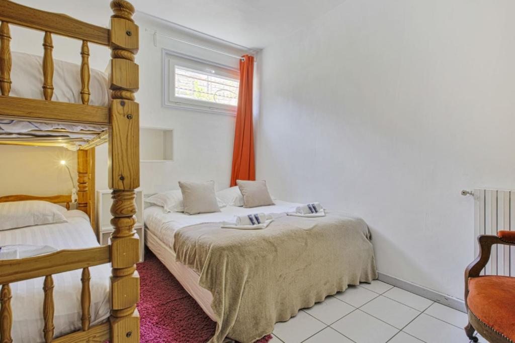 1 Schlafzimmer mit 2 Etagenbetten und einem Fenster in der Unterkunft Charming Basque villa with garden - Bayonne - Welkeys in Bayonne