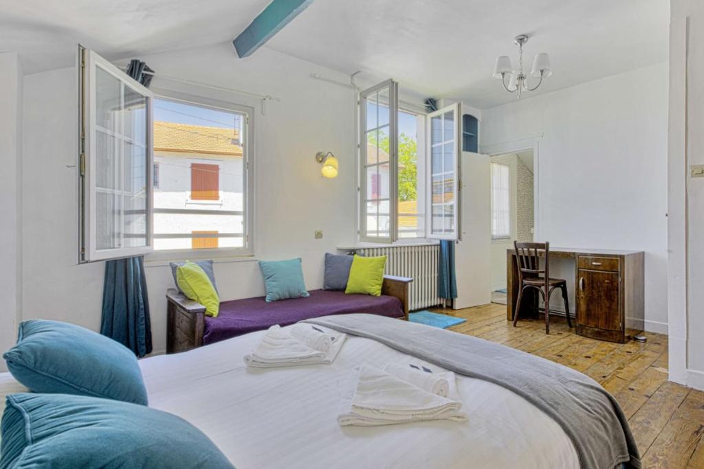 ein Schlafzimmer mit einem Bett, einem Sofa und Fenstern in der Unterkunft Charming Basque villa with garden - Bayonne - Welkeys in Bayonne