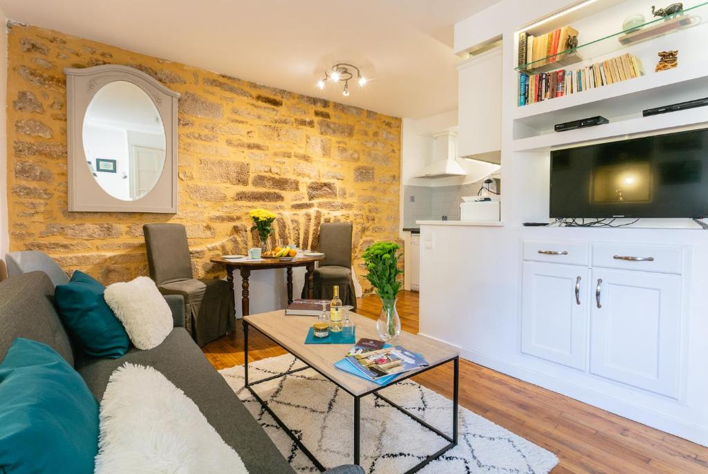 a living room with a couch and a table at La Ritournelle in Sarlat-la-Canéda