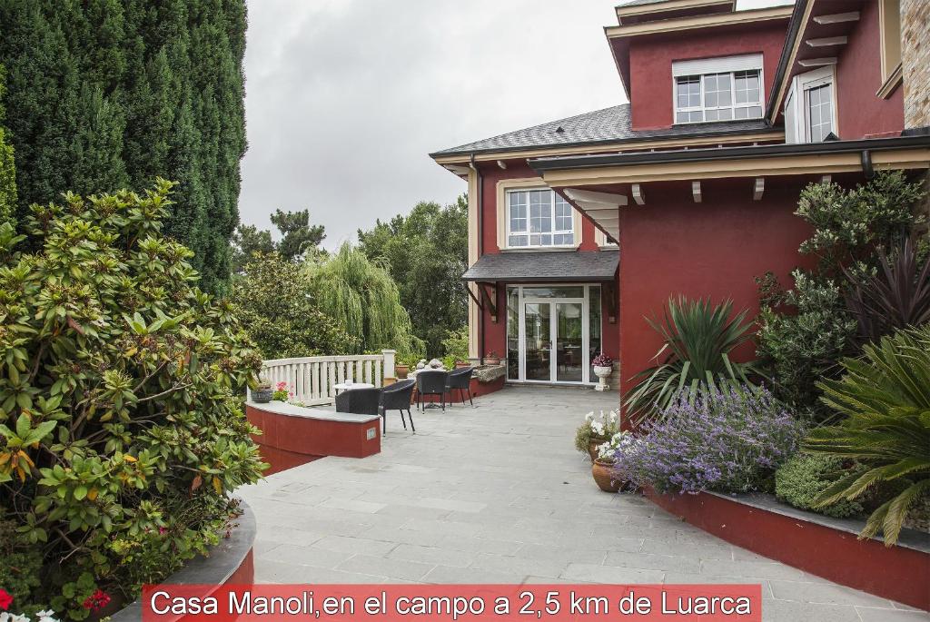 ein rotes Haus mit einer Terrasse davor in der Unterkunft Casa Manoli Luarca in Almuña