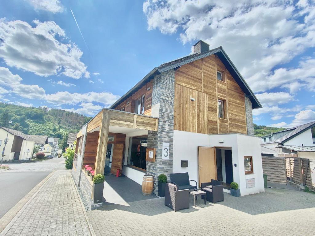 a small building with a wooden roof on a street at JUULS - Natur Hotel Garni in Simmerath
