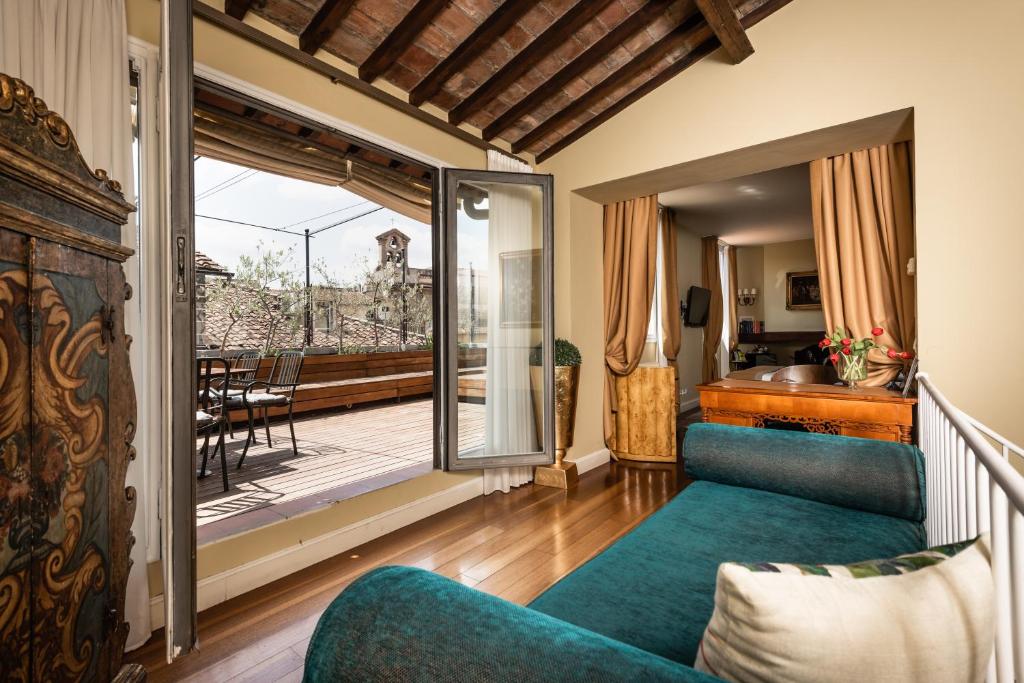 uma sala de estar com um sofá azul e uma varanda em AQA Palace em Florença