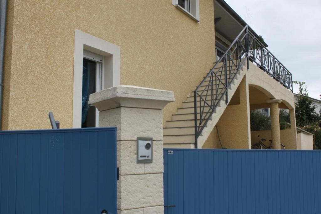 ブールゴアンにあるLe Panoramaの階段のある家の前の青い柵