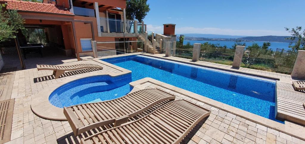 una piscina con tre sedie accanto a una casa di Villa LKL a Kaštela (Castelli)