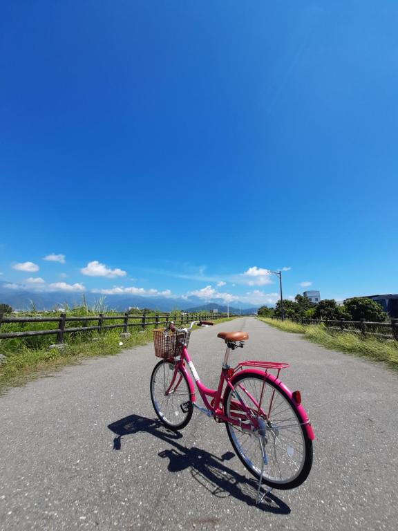 una bici rossa parcheggiata sul ciglio di una strada di Love Travel Guest House a Città di Taitung